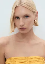 Top bandeau color amarillo con diseño fruncido, sin mangas y cierre de cremallera en la parte posterior.