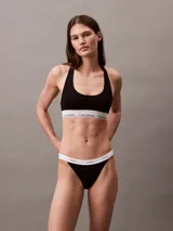 Conjunto Calvin Klein negro, compuesto por un corpiño deportivo con elástico con logo y una tanga con elástico con logo.