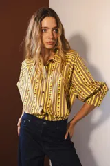 Camisa de manga larga con estampado de rayas verticales verdes y blancas con flores rojas.