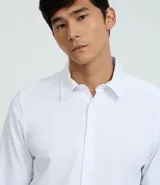 Camisa de vestir celeste en modelo slim fit, con cuello inglés, abotonada adelante, de manga larga con botones en los puños. Confeccionada con tecnología easy care performance que permite mayor elasticidad, secado rápido y menos arrugas.