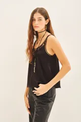 Top tipo musculosa confeccionado en modal satén, color negro, con terminación de calado en el escote delantero y en la espalda, acompañado de bordados a tono.