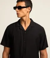 Camisa de hombre color verde claro, corte slim, de manga corta y cuello inglés. Confeccionada en viscosa texturizada.