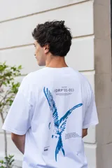 Remera blanca de algodón con estampado azul en la espalda que incluye un pájaro, texto y el logo de la marca Kangu.