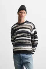 Jersey de hombre con corte relaxed, cuello redondo y manga larga. Diseño con patrón geométrico jacquard en tonos negro, gris y blanco.