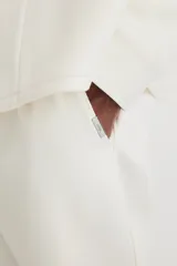 Pantalón jogger color crudo, de corte slim fit, confeccionado en sarga. Presenta cintura elástica con cordón ajustable, bolsillos laterales al bies y bolsillos traseros insertados.
