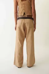 Pantalón de jean color arena, de corte ancho y tiro bajo.