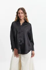Camisa negra de manga larga confeccionada en tela satinada.