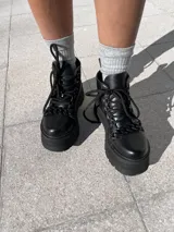 Botas negras de ecocuero con detalle de cadena en la parte delantera y taco de 6cm.