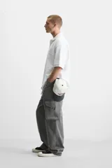 Polo blanco de piqué con corte relaxed fit, cuello solapa y cierre frontal con botones.