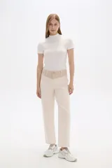 Pantalón de jean color beige, de corte recto y calce medio. Presenta bolsillos delanteros y traseros.