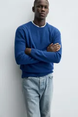 Sweater verde oscuro de punto, con cuello redondo y manga larga. Tejido en hilatura con mezcla de lana y acabados en rib.