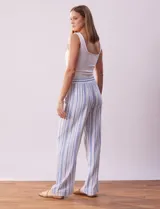 Pantalón de lino a rayas verticales color beige y blanco, con pretina ancha elastizada, lazo de ajuste y bolsillos inclinados.