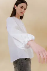 Camisa negra de lino con cuello mao, mangas abullonadas con elástico en los puños y botones forrados en la misma tela.