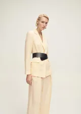 Pantalón de vestir color crema, de tiro medio y corte recto. Con cierre delantero de botón, gancho y cremallera ocultos con tapeta, trabillas y detalle de pinzas.