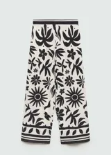 Pantalón wide leg de viscosa con estampado floral en blanco y negro. Tiene cintura elástica, dos bolsillos laterales y diseño largo.