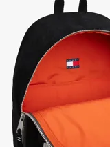 Mochila negra de nailon con diseño monocromático y paneles texturizados. Presenta un parche tonal con el logo de Tommy Jeans en la parte delantera y un bolsillo exterior con cremallera.