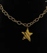 Collar dorado con cadena de eslabones y dije de estrella.