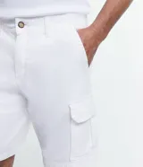 Bermuda cargo azul marino para hombre, confeccionada en algodón. Cuenta con múltiples bolsillos utilitarios laterales, trabillas en la cintura y cierre con botón y cremallera.