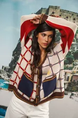 Cardigan oversized de tejido jacquard color crema con diseño de cuadrados en marrón y detalles bordados. Tiene cuello en V, cierre con botones, mangas largas y bolsillos frontales.