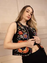 Chaleco negro con bordado floral multicolor, sin mangas y corte recto.