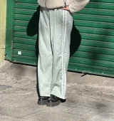Pantalón deportivo color verde agua, de corte holgado, con cintura elástica y tres rayas blancas verticales a los costados.
