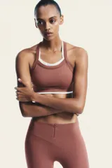 Top deportivo color ladrillo con escote redondo y tirantes blancos.