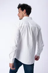 Camisa blanca de manga larga, corte clásico, con cuello abotonado y bolsillo en el pecho.