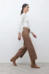 Pantalón tipo culotte de jean color marrón tostado, con tiro alto, bolsillos delanteros tipo parche y terminación deshilachada en el ruedo.