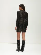 Minivestido negro de lentejuelas con mangas largas y cuello redondo.