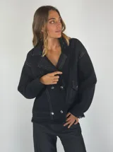 Chaqueta negra con diseño oversize y costuras visibles, de corte moderno.