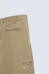 Pantalón color caqui de corte amplio, con pinzas en la cintura, bolsillos laterales y traseros con botón.