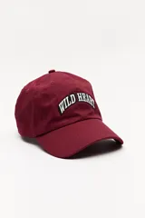 Gorra de béisbol color bordó con bordado frontal de la frase "Wild Heart" en blanco.