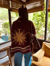 Cardigan tejido artesanalmente en lana color crudo, con diseño de copo de nieve en la espalda y bordados a mano.