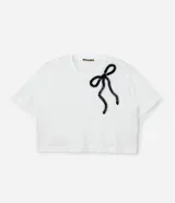 Remera blanca de algodón con cuello redondo, mangas cortas y aplicación de cinta contrastante formando un lazo negro en el frente.