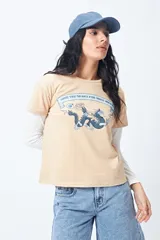 Remera color beige de manga corta con cuello redondo y estampado con ilustración gráfica al frente y frase retro.
