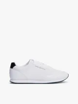 Zapatillas Tommy Hilfiger blancas de estilo running, con suela dentada fina y logo de la marca en el lateral.