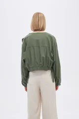 Campera verde oliva con cierre frontal, cuello redondo y corte a la base.