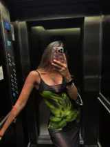 Vestido largo de microtul negro con estampado de flores verdes.