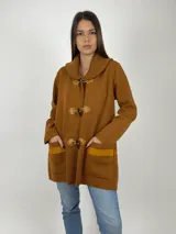 Saco marrón de tejido de punto fino en lana, con cuello alto tejido en punto grueso y cierre con trabillas de cuero.