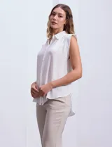 Blusa negra de gasa marca Tahari, con cuello a la base con solapa, abertura central con botones ocultos y detalle plisado en hombros.