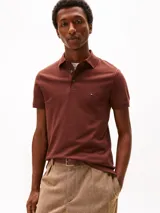 Chomba color ladrillo de Tommy Hilfiger, corte slim, con cuello clásico, tapeta de dos botones y logo bordado en el pecho.