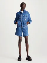 Campera de denim rígido azul con cuello en punta, bolsillos de parche y bajos ajustados.
