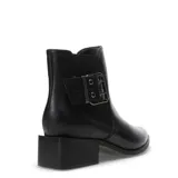 Botas cortas de cuero sintético color negro, con diseño de punta fina y taco cuadrado bajo. Presentan un detalle de tira con hebilla metálica en el lateral y paneles elásticos para un ajuste cómodo.