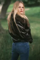 Jeans de denim azul oscuro con efecto lavado y desgaste sutil en la parte delantera de los muslos y las rodillas. Diseño de tiro alto, cinco bolsillos y corte acampanado desde la rodilla hacia el bajo.