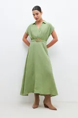 Vestido midi color verde pistacho, de corte evasé, con cuello camisero, mangas cortas y cinturón con hebilla redonda.