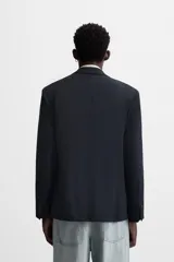 Blazer slim fit color azul marino confeccionado en tejido con viscosa. Cuello con solapas de muesca, manga larga con puño con detalle de botones, bolsillo de vivo en pecho y de solapa en cadera, bolsillo interior, bajo con aberturas en espalda y cierre frontal con botones.