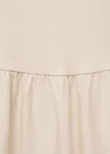 Vestido midi color crudo, de corte evasé, con breteles anchos y escote redondo.