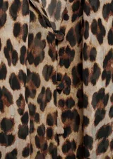 Blusa de tejido fluido con estampado animal print, lazo en el cuello, escote de pico, manga larga murciélago y cierre delantero con botones.