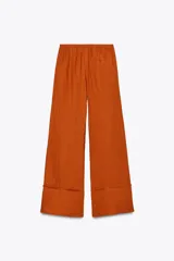 Pantalón palazzo color ladrillo confeccionado en lino 100%, de tiro medio con cintura ajustable con cordones, bolsillos laterales ocultos en costura y pierna ancha.