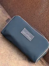 Neceser de lona verde con detalles en cuero color beige y etiqueta con logo de la marca Sierra Mora.